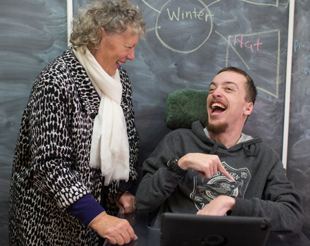 Young man in a wheelchair with his teacher