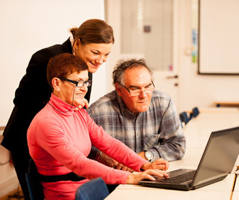Three people looking at a laptop